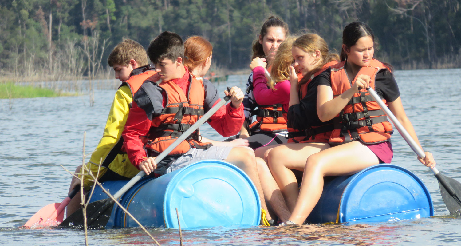 Year 10 Genesis students paddling a raft they made themselves while on camp